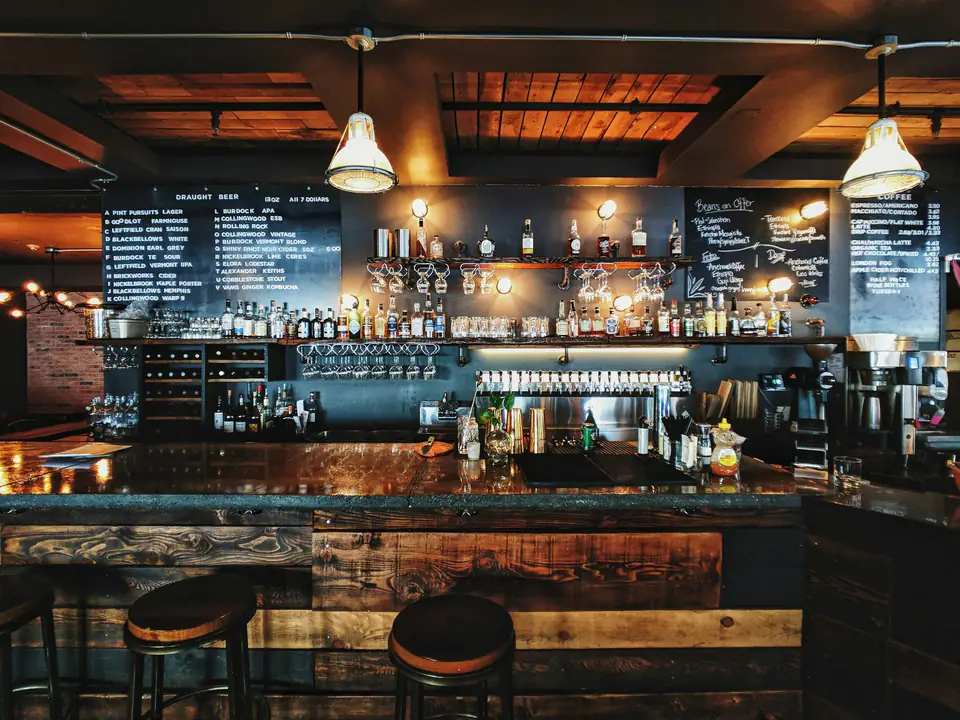 Barra del bar con taburetes y pizarras
